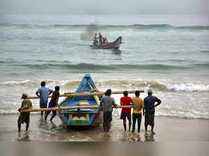 Puri: Fishermen shift their boats in preparations for Cyclone Dana, in Puri. (PT...