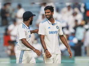 Pune: India's Washington Sundar and Jasprit Bumrah celebrate the wicket of New Z...