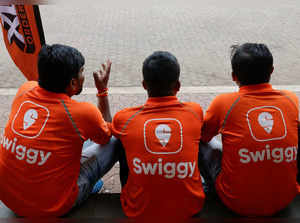 Swiggy gig workers talk to each other during a promotional event in Mumbai