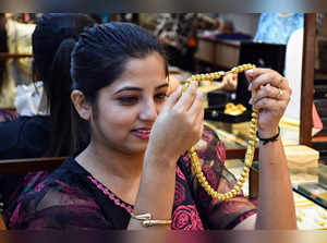 Guwahati, Oct 26 (ANI): A woman shops for gold jewelry at a showroom ahead of th...