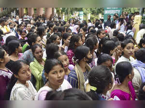 Guwahati: Candidates wait in a queue outside an examination center as they appea...