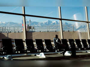 With the Wasatch Mountains in the background, a passenger waits at Salt Lake City International Airport in Utah