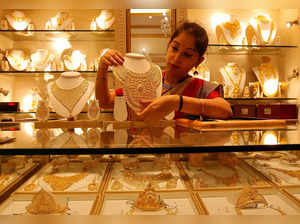 FILE PHOTO: FILE PHOTO: A saleswoman displays a gold necklace inside a jewellery showroom on the occasion of Akshaya Tritiya, a major gold buying festival, in Kolkata