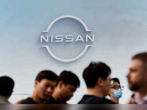 FILE PHOTO: Visitors walk past a Nissan logo at the Beijing International Automotive Exhibition