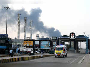 An ambulance moves as smoke billows from an Indian Oil Corporation refinery after a fire in Vadodara