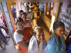 Nagaon: Voters wait in a queue at a polling station to cast votes during Samagur...