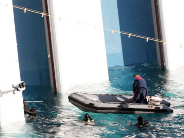 Italian naval divers approach the cruise ship Costa Concordia