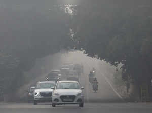 Traffic passes by on a road as the sky is enveloped with smog after Delhi's air quality was classified as "hazardous" amidst severe air pollution, in New Delhi