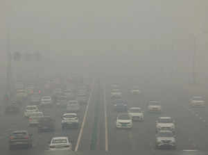 Traffic passes on a road as the sky is enveloped with smog after Delhi's air quality turned "severe" due to alarming air pollution, in New Delhi