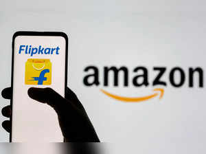 Smartphone with Flipkart logo is seen in front of displayed Amazon logo in this illustration taken