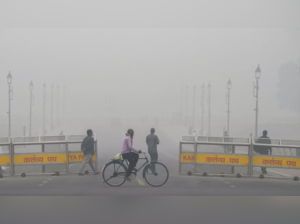 A man cycles near the India Gate amid low visibility due to smog (PTI photo)