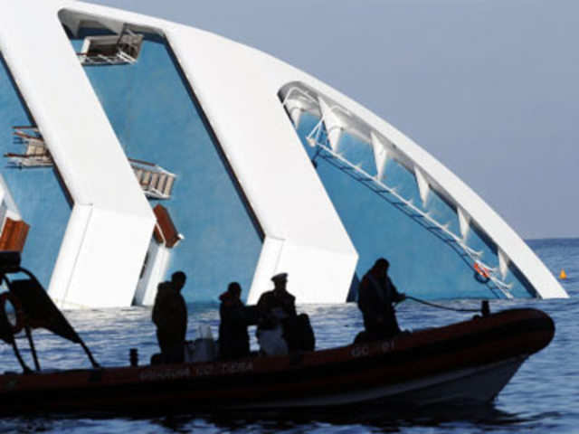 A samll boat of the coast guard passes by the cruise liner Costa Concordia