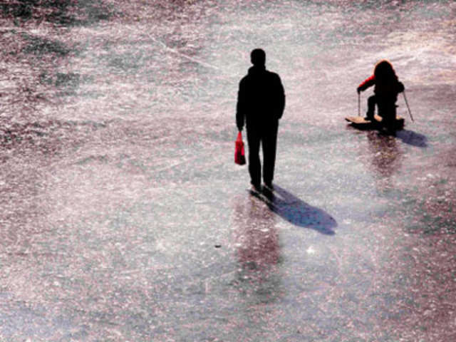 A man walks across a frozen pond at Ritan Park