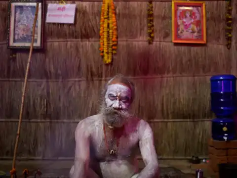 A Naga Sadhu, or a Hindu holy man, sits covered in ashes during the Maha Kumbh Mela