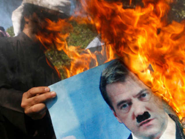 A Kuwaiti demonstrator holds a burning portrait of Russian President Dmitry Medvedev