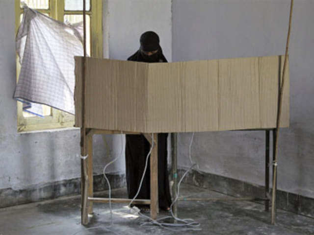 A veiled woman casts her vote at a polling booth