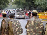 Policemen watch security and forensic officials