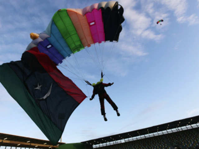 Parachuters descend in the sky during an event