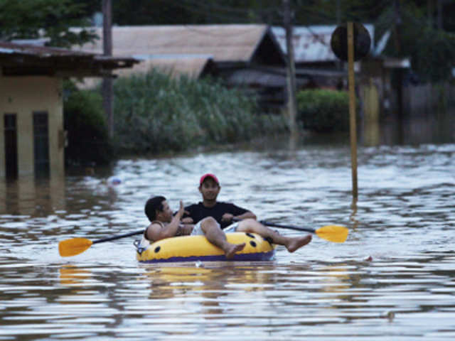 Men use a raft to navigate the flooded streets in Cobija