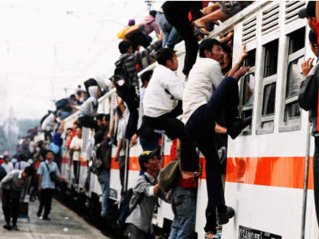 People climb up to the roof of a train in Jakarta