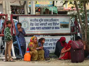 Pakistani citizens take shelter under a tree as they wait to leave for Pakistan at the Attari-Wagah border crossing with Pakistan, near Amritsar