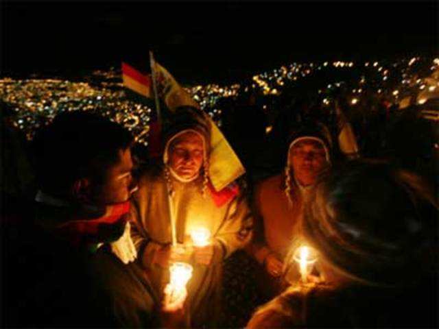 Venezuelans holding candles participate in an Aymara ceremony