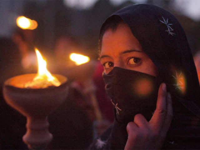 A woman holds a torch while taking part in a rally to commemorate International Women's Day in Islamabad
