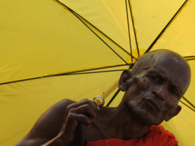 A Sri Lankan Buddhist monk holds an umbrella during a protest in Colombo