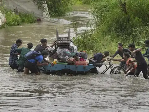 Locals push cart in floodwaters