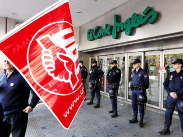 Police guard a store during a general strike in Spain
