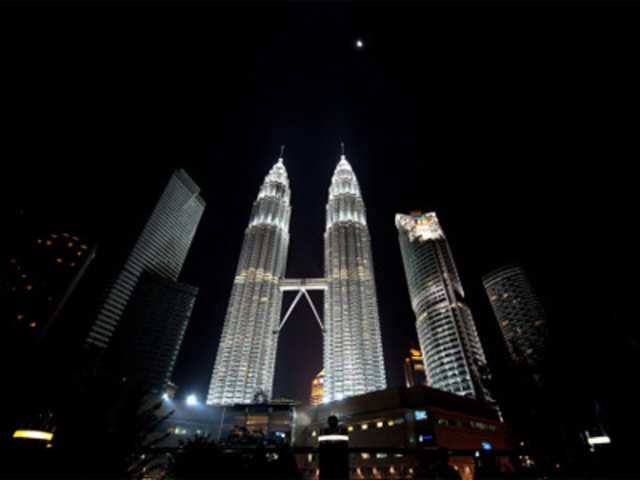 Malaysia's Patronas Twin Towers stand illuminated before its lights are turned off to mark Earth Hour