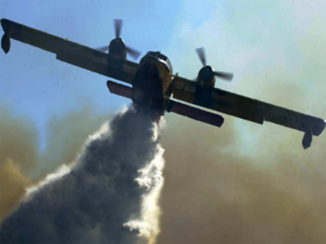 A Canadair drops water on a wildfire