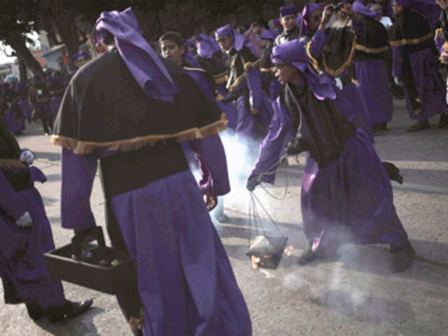 A child burns incense during the procession