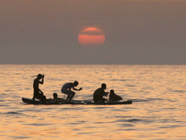 Palestinian fishermen fish at sunset off Gaza City