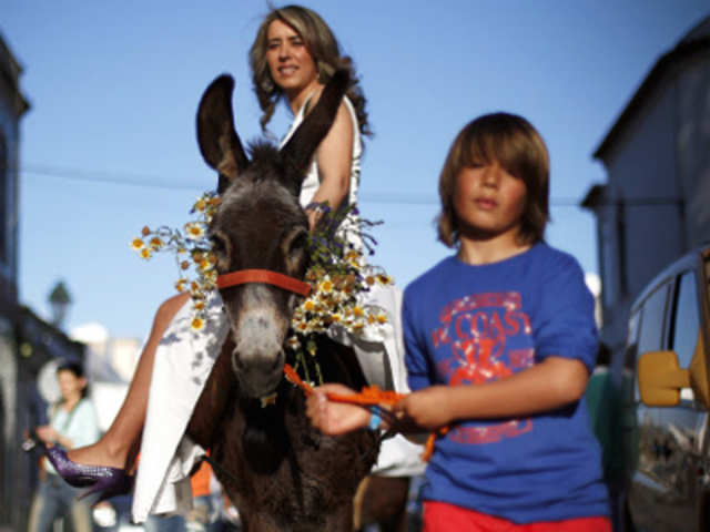 A woman rides a donkey during the 'Virgem da Atalaia' procession
