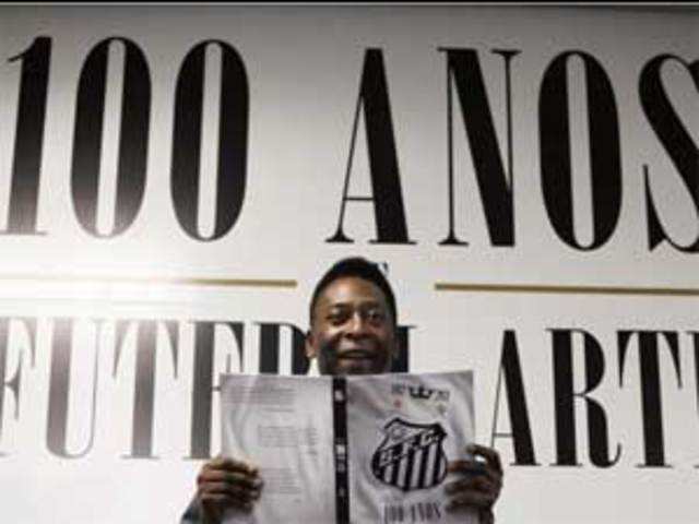 Pele holds a book during a ceremony in Santos
