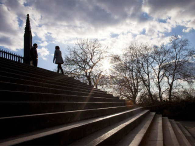 People walk in evening sun on steps of Liberation Wars Memorial in Victory Park