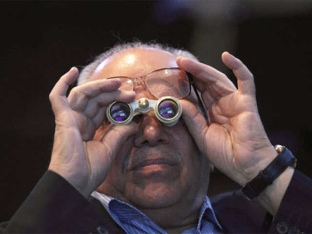 Investor uses binoculars as he looks at Iraq Stock Exchange stocks
