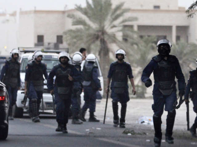 Riot policemen run after Bahraini anti-government protesters in Budayya avenue, outside Manama