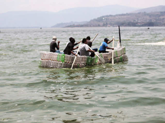 Men row a boat made of plastic bottles in the Amatitlan lake