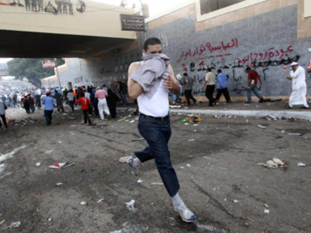 Protesters run for cover after army troops fired tear gas