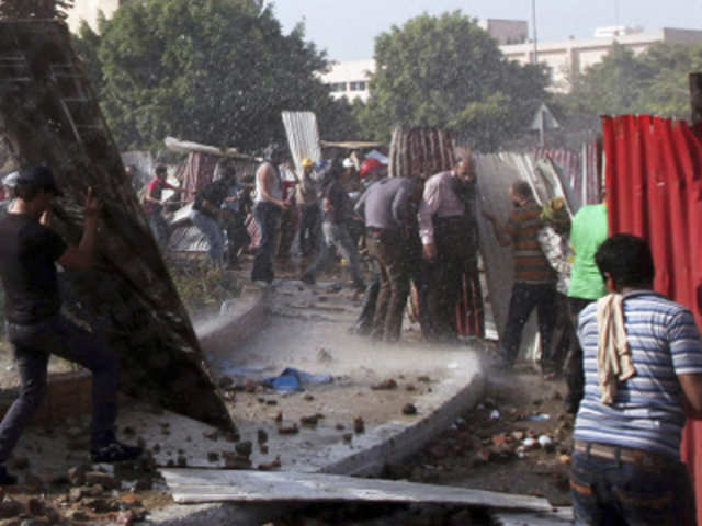 Protesters take cover as stones are thrown during clashes in Cairo