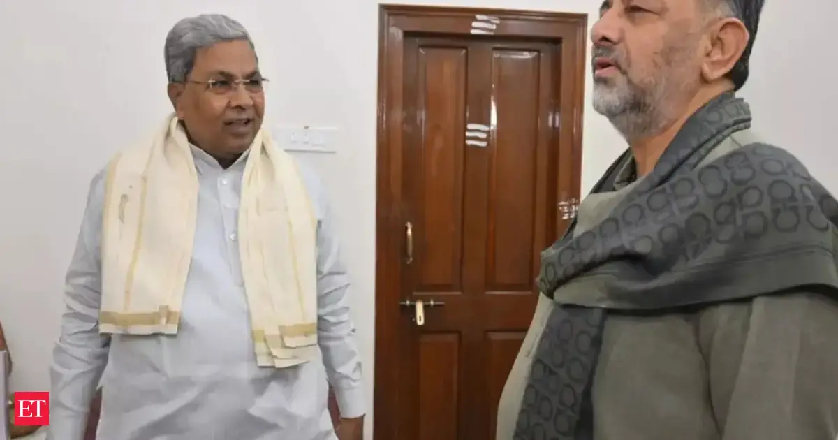 Karnataka Deputy Chief Minister D.K. Shivakumar speaking, with Chief Minister Siddaramaiah in the background, symbolizing state leadership discussions.