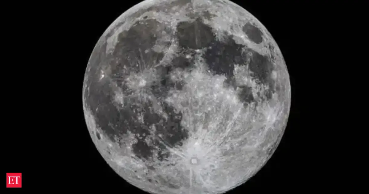 A slightly smaller full moon (micromoon) glows in a dark night sky, with subtle hints of spring flowers, representing May's Flower Micromoon.