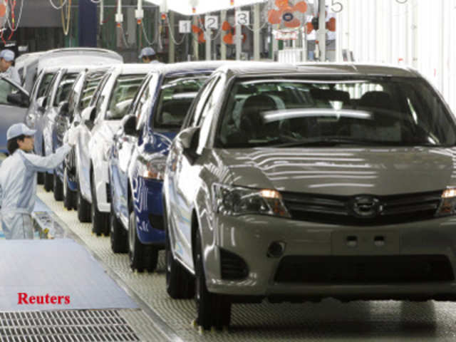 Workers check newly produced Corolla vehicles