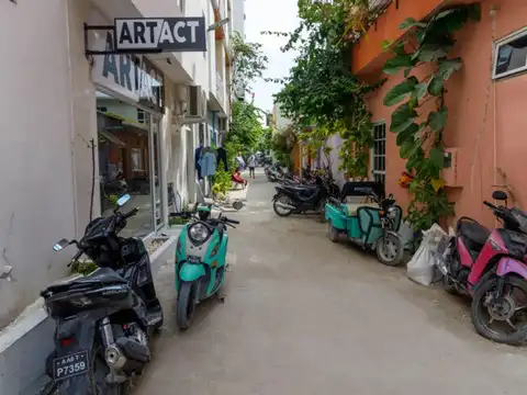 Beneath parked vehicles that rarely move