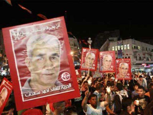 Palestinians hold Saadat portraits as they celebrate Ramallah
