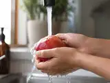 Most people rinse apples under the tap, but a study found plain water barely touches pesticide residue; a baking-soda soak removed up to 96% of it