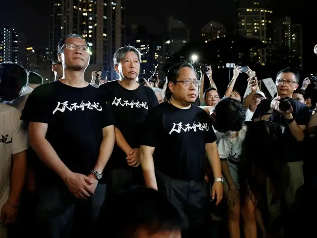 FILE PHOTO: Pro-democracy activists Richard Tsoi Yiu Cheong, Lee Cheuk-yan, Albert Ho Chun-Yan pay tribute to those who died during a candlelight vigil at Victoria Park in Hong Kong