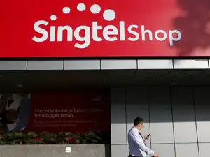 FILE PHOTO: A man passes a Singtel logo outside their head office in Singapore